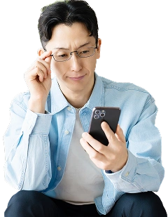 スマートフォンを見て購入について悩む男性